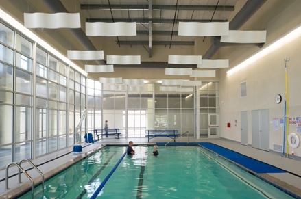 This is a picture of a pool inside a building with glass walls